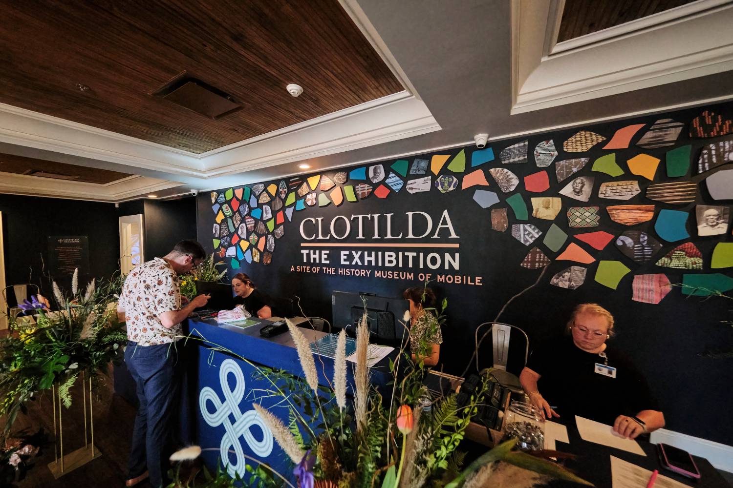 Visitors checking in at the Clotilda: The Exhibition welcome desk inside the History Museum of Mobile exhibition space